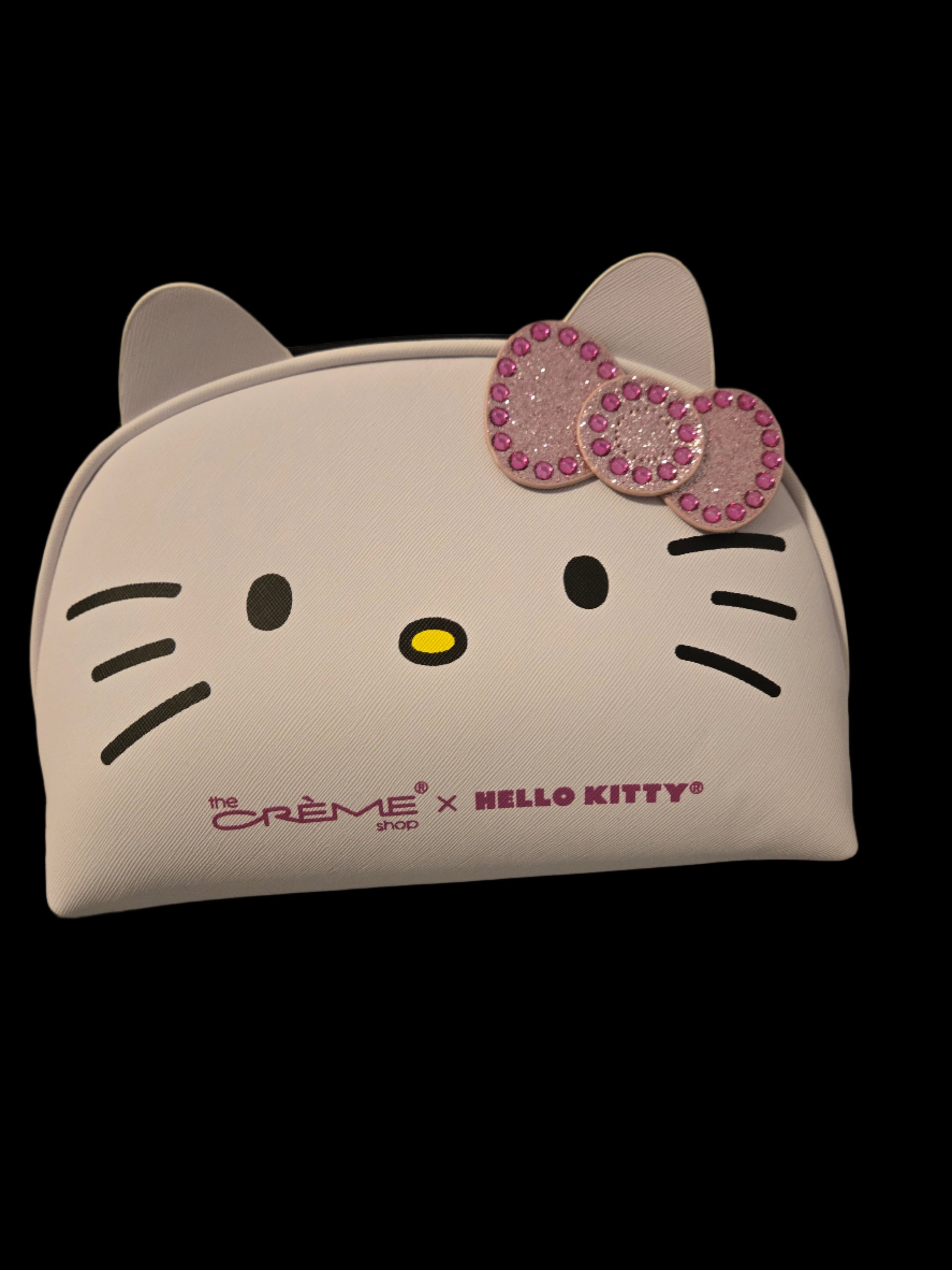 Hello Kitty face-shaped pillow with a bow on a gray surface