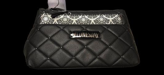 Black quilted handbag with 'Wednesday' branding on a beige background